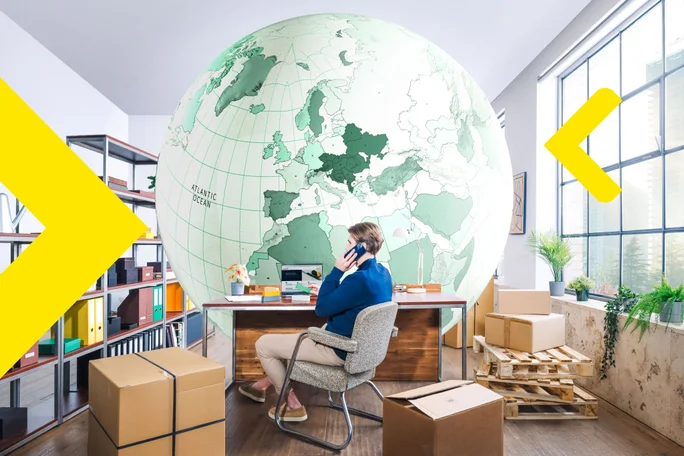 Businessman on call with large world map in office setup, planning global logistics