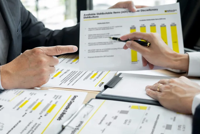 Fachleute arbeiten gemeinsam an detaillierten Finanzdiagrammen und -dokumenten und konzentrieren sich in einem Geschäftsmeeting auf strategische Planung und Datenanalyse.