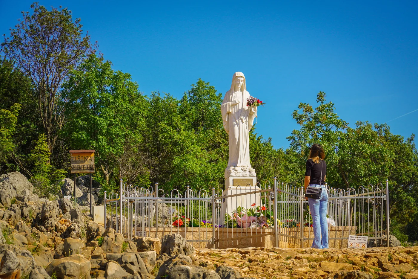 People praying in front of the statue of the Mother of God in the place of her apparitions - Medjugorie
