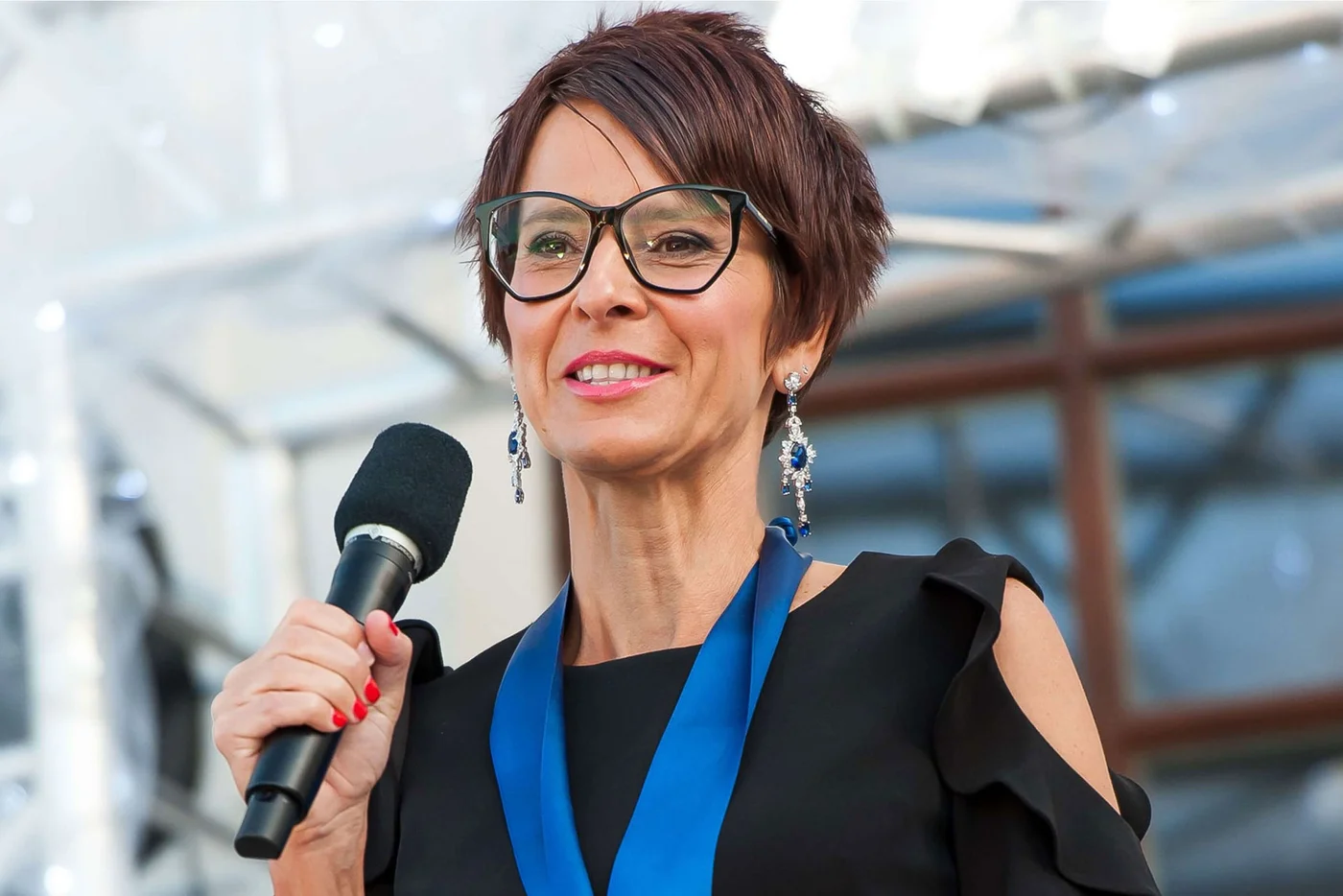 Portrait of Zuzana Kostialova holding a microphone