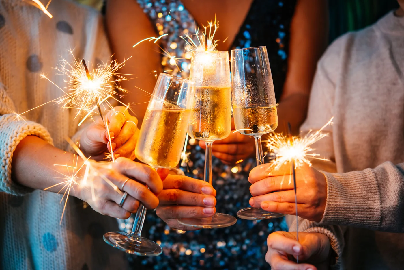 Friends celebrating Christmas or New Year's eve with Bengal lights and champagne.