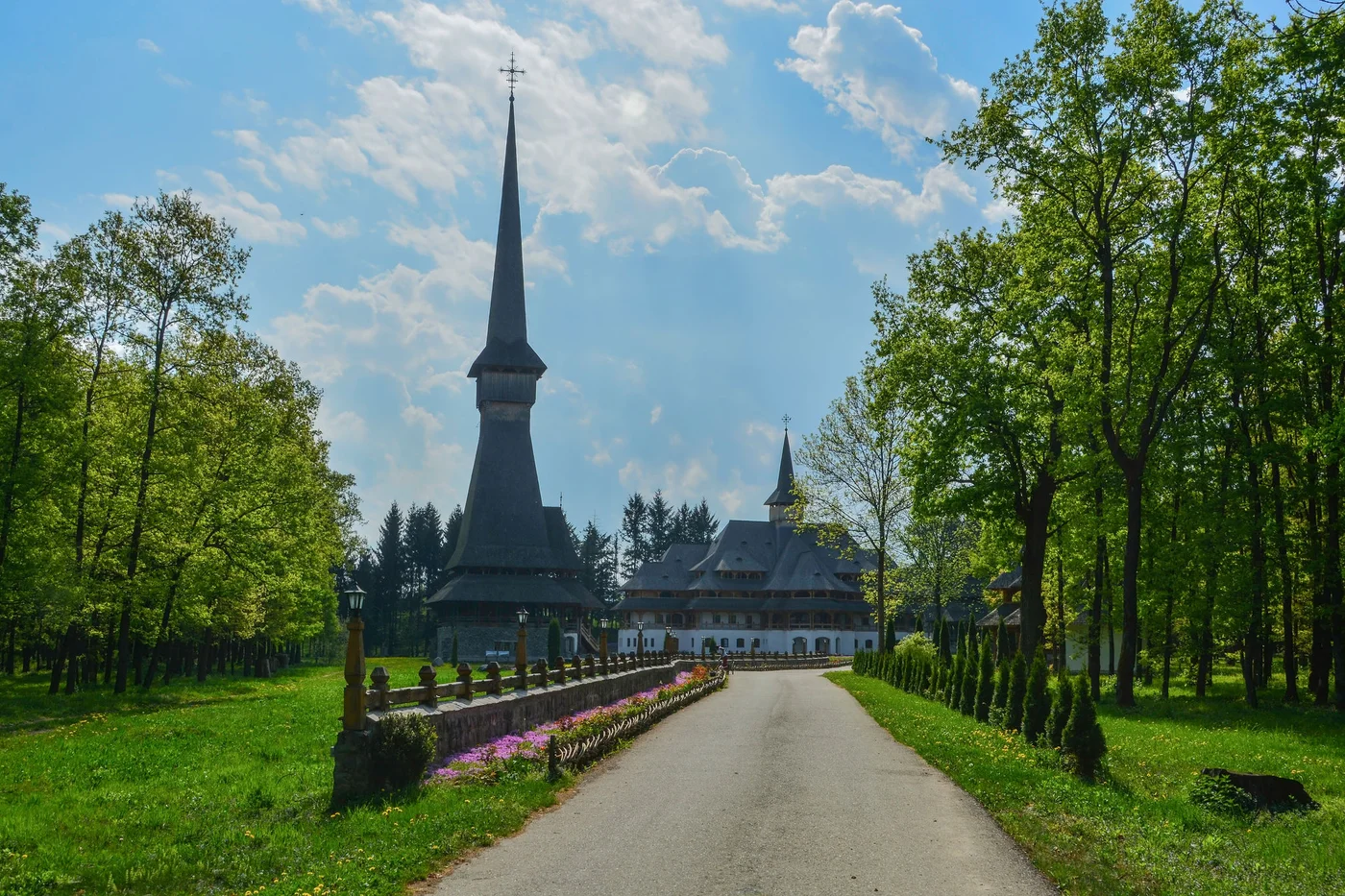 Sapanta Peri Monastery, Maramures, Romania, Europe, spring 2018. Traditional wooden church with the tallest bell tower in the world. Maximum height of 78 meters. Surrounded by vegetation.