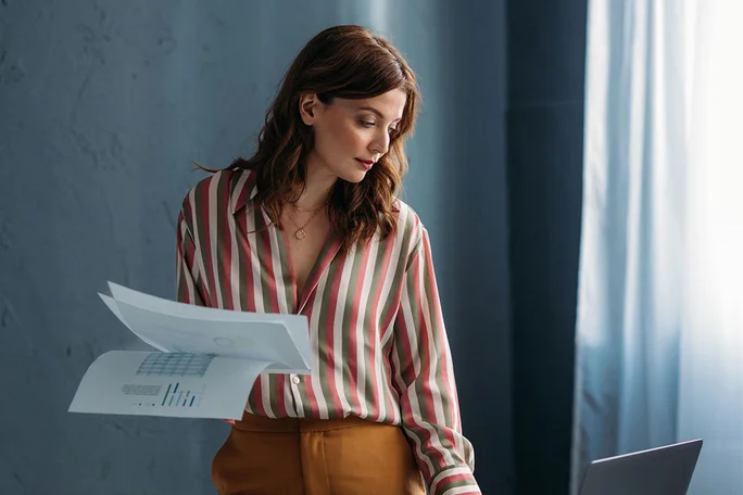 A professional reviewing financial documents in a contemporary office setting.