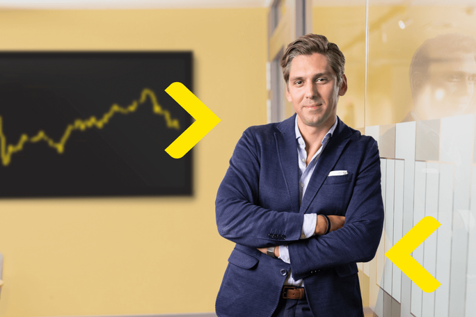 A confident professional standing with arms crossed in a modern financial office. The background features a graph chart, symbolizing data analysis and financial growth. The image conveys a sense of professionalism and expertise in financial services.