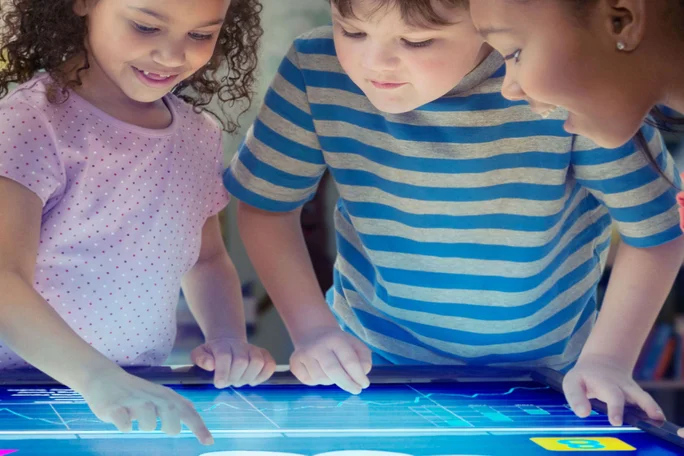 Kinder spielen mit einem Display