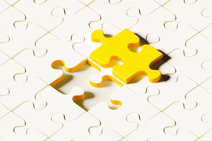 A bright yellow puzzle piece fitting perfectly into a white puzzle, representing the concept of solving problems and achieving goals.