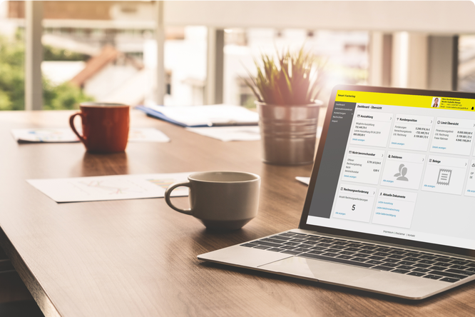 Ein moderner Arbeitsplatz mit einem Laptop, auf dem Finanzmanagementsoftware läuft, umgeben von Kaffeetassen und Dokumenten, ideal für Remote-Arbeit und Geschäftsanalysen.