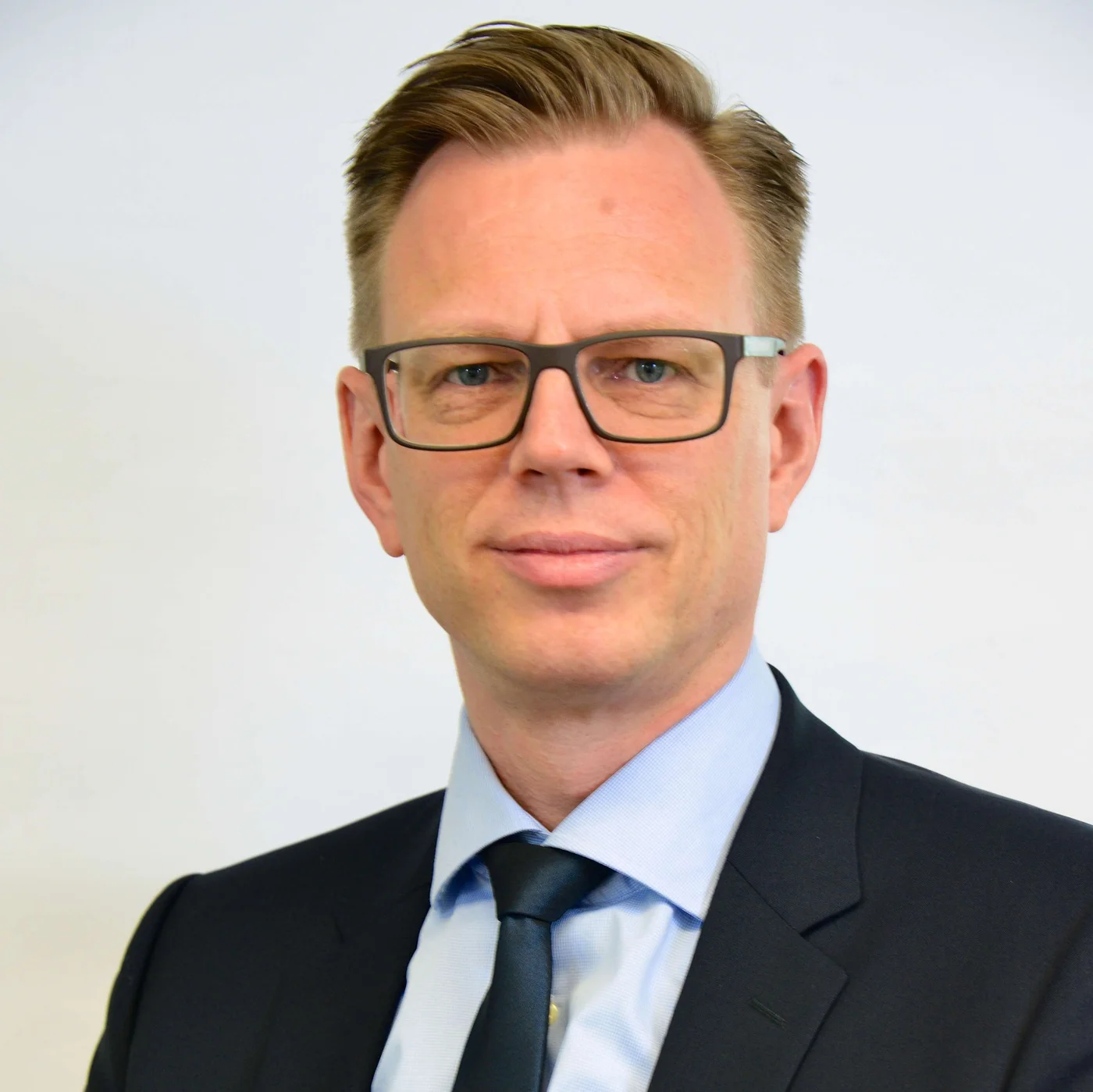 A person dressed in a formal business suit and tie, exemplifying professionalism and corporate readiness.