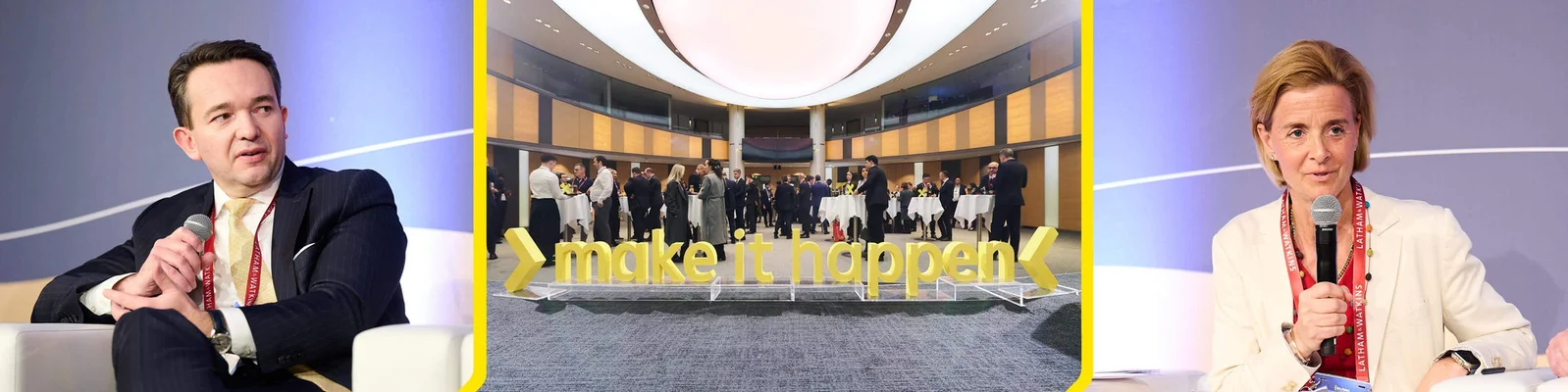 Eine Geschäftskonferenz mit Diskussionsteilnehmern auf der Bühne mit Mikrofonen und einem zentralen Bereich, in dem Teilnehmer sich um ein großes gelbes "make it happen"-Schild vernetzen.