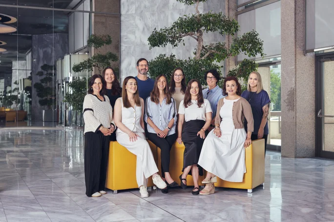 Ein dynamisches Gruppenfoto von Fachleuten, vereint durch den motivierenden Satz "Make It Happen", das Ehrgeiz und kollektiven Antrieb zeigt.