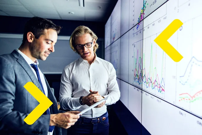 Two men discuss financial visualizations, Investment  Subsidized Financing