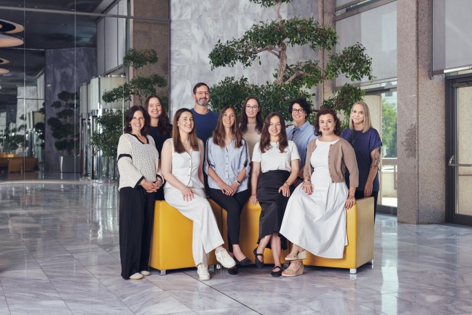 Ein dynamisches Gruppenfoto von Fachleuten, vereint durch den motivierenden Satz "Make It Happen", das Ehrgeiz und kollektiven Antrieb zeigt.