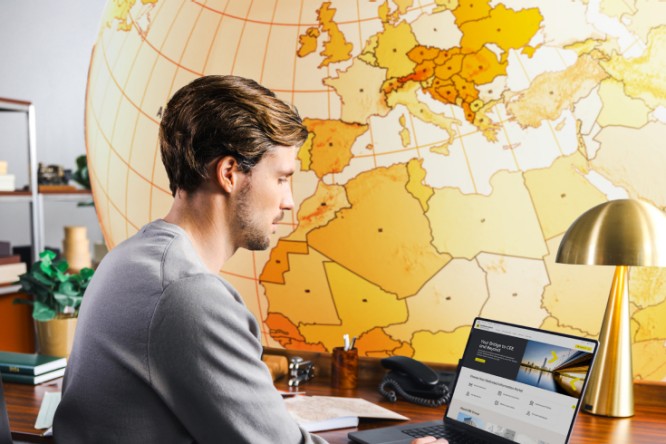 Man sitting at desk looking at RBI's international network page with a large globe in the background