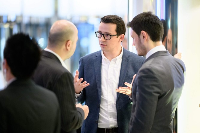 Business man talking, a goup of three people visible