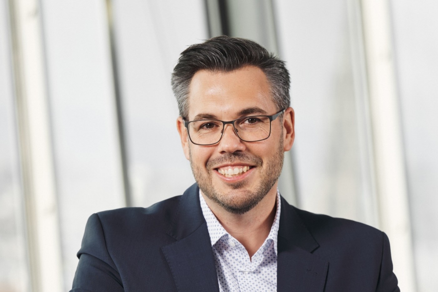Portrait of a smiling business man in a corporate setting, illustrating leadership and innovation in financial strategy