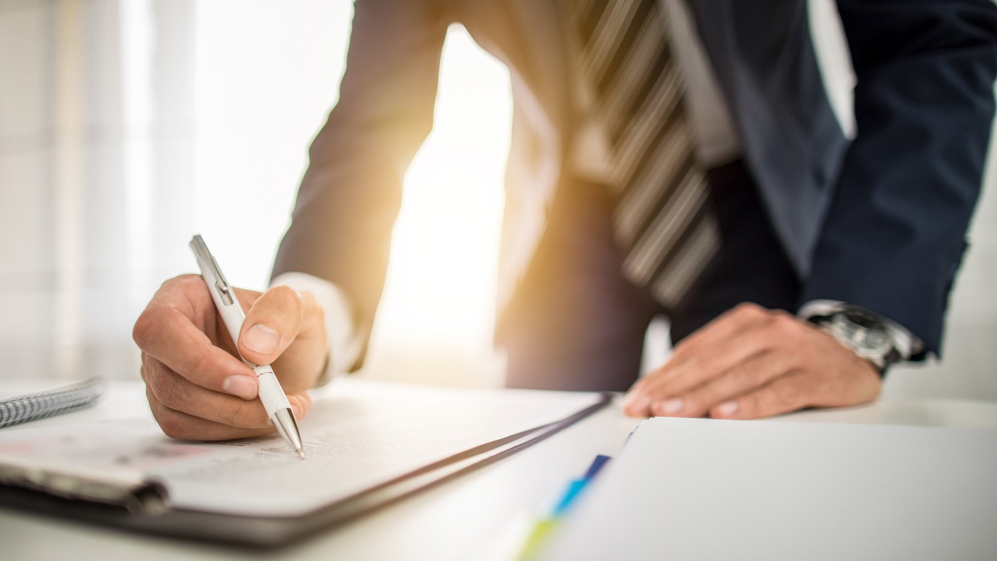 Man in suit signing paper
