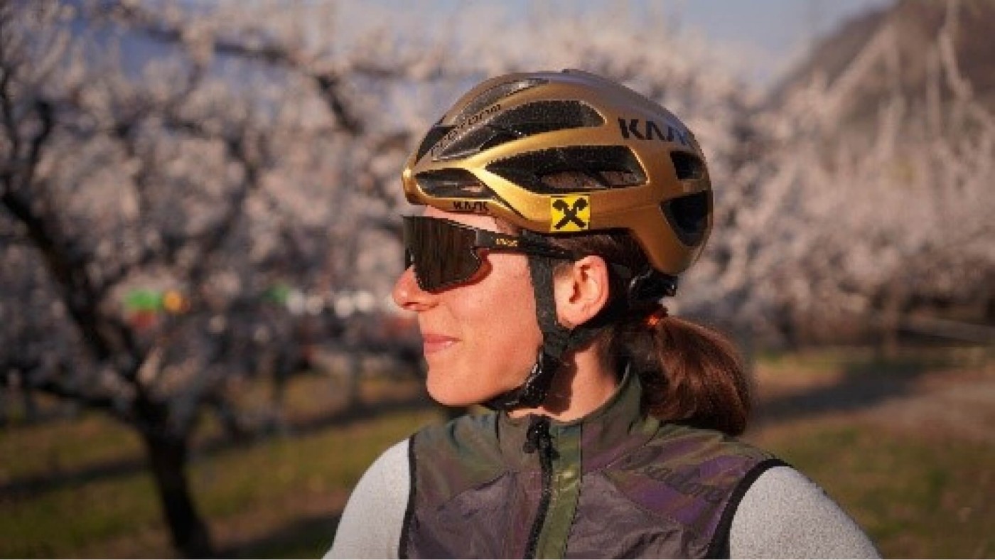 Porträt von Anna Kiesenhofer als Radfahrerin mit Brille und Helm