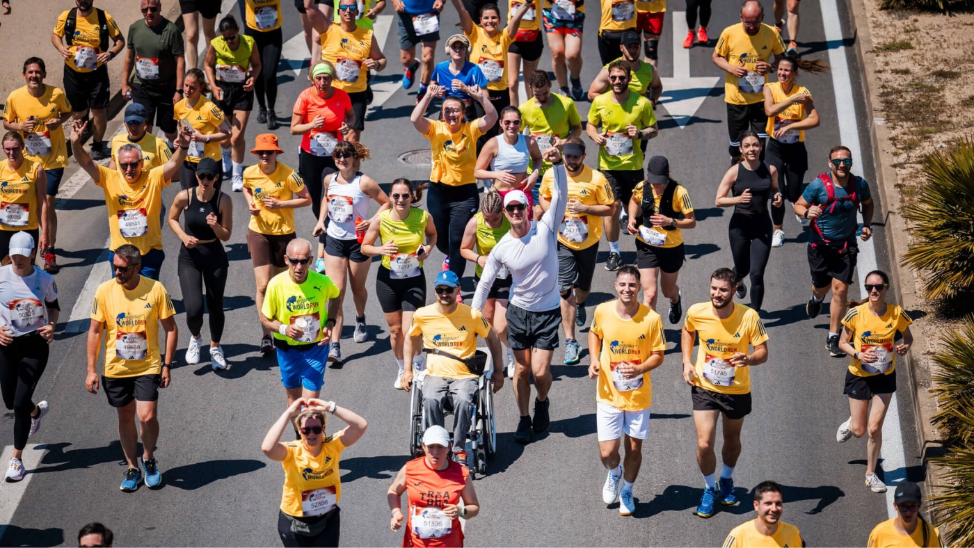 Eine vielfältige Gruppe von Läufer:innen nimmt an einem Marathon an einem sonnigen Tag teil – steht für Teamgeist und Entschlossenheit.