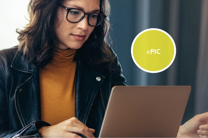Eine Person im senfgelben Rollkragenpullover und schwarzen Lederjacke arbeitet an einem Laptop, daneben ist ein rundes ePIC-Digitalservice-Icon zu sehen.